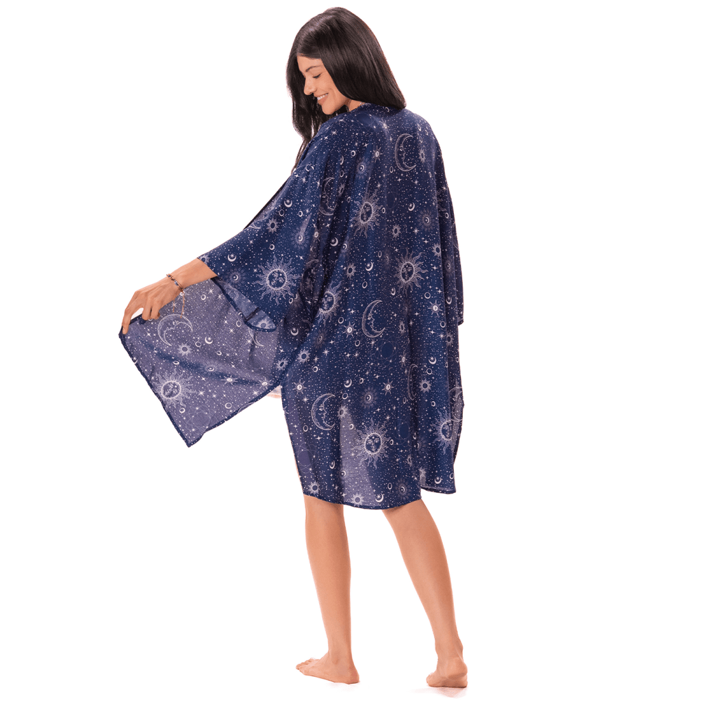 Woman wearing a dark indigo blue kimono with celestial pattern on a white background