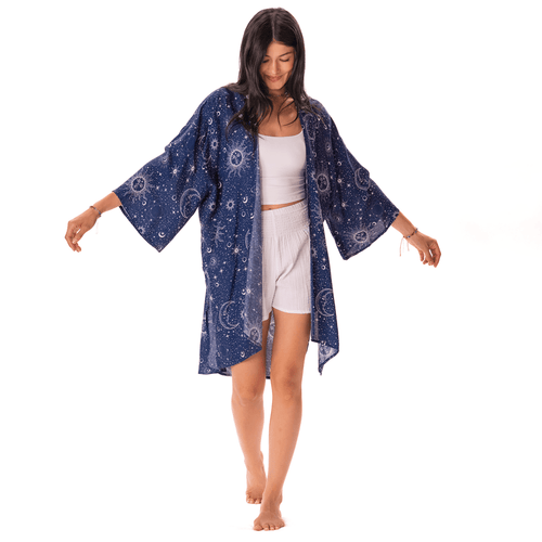 Woman wearing a blue patterned kimono over a white outfit on a white background