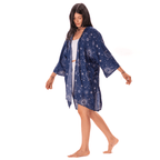 Woman wearing a blue patterned kimono over a white dress on a white background