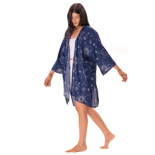 Woman wearing a blue patterned kimono over a white dress on a white background