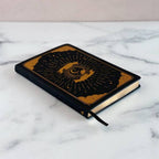 Black intention and mindfulness notebook with gold design on a marble surface