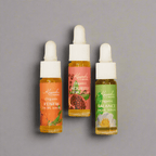 Travel-size Kuumba Made Botanical Facial Serum Discovery Gift Set with Balance, Nourish, and Renew serums on neutral gray background.