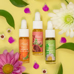 Kuumba Made Botanical Facial Serum Discovery Gift Set with three organic serums surrounded by flowers and leaves on yellow background.