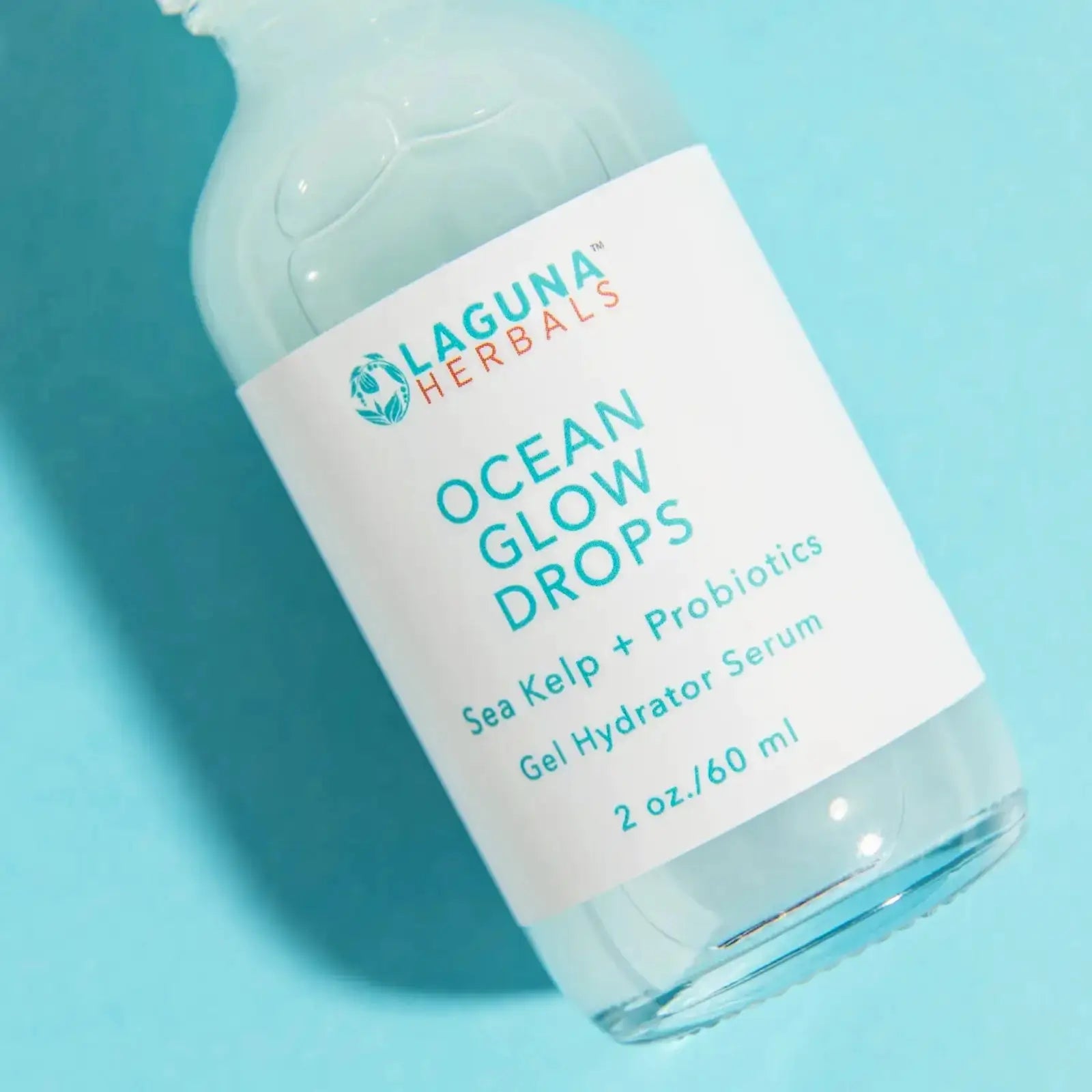 Bottle of Laguna Herbals Ocean Glow Drops Probiotic Face Serum on a blue background