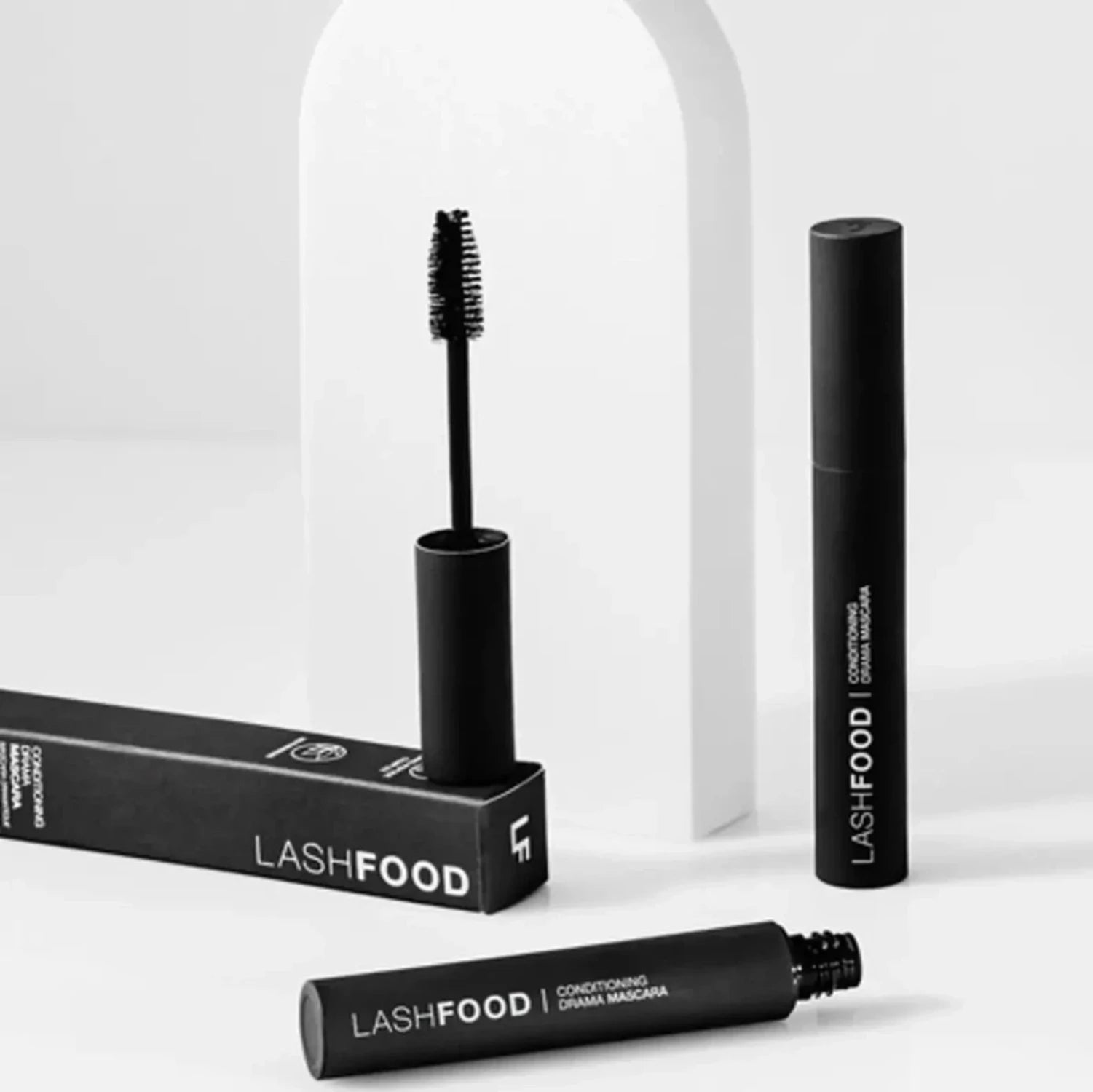 Two tubes of black Lashfood Mascara on display showcasing the extra-large lengthening, and defining bristle brush.