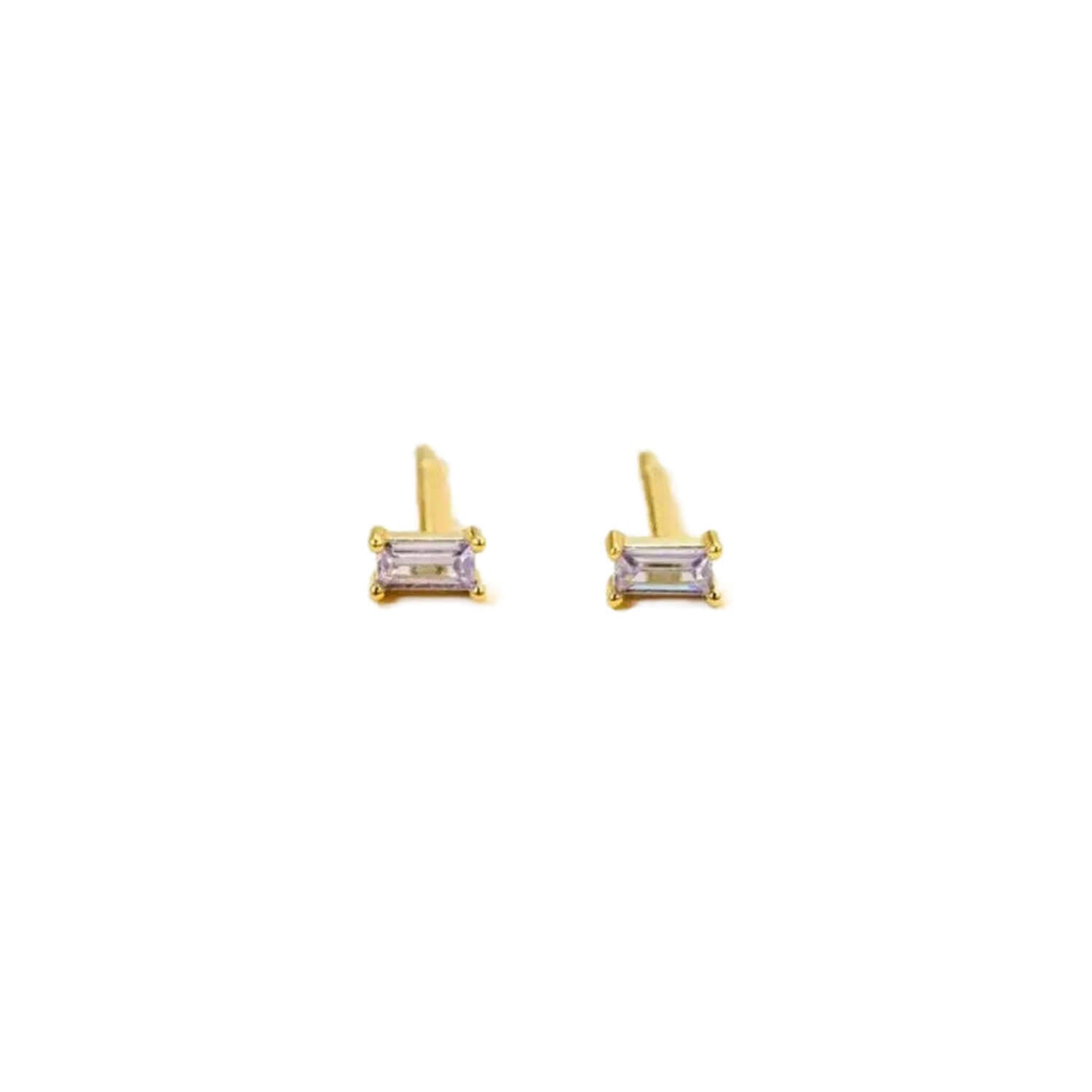 a pair of stud earrings in lilac colored cubic zirconia baguette shaped stones set in yellow gold