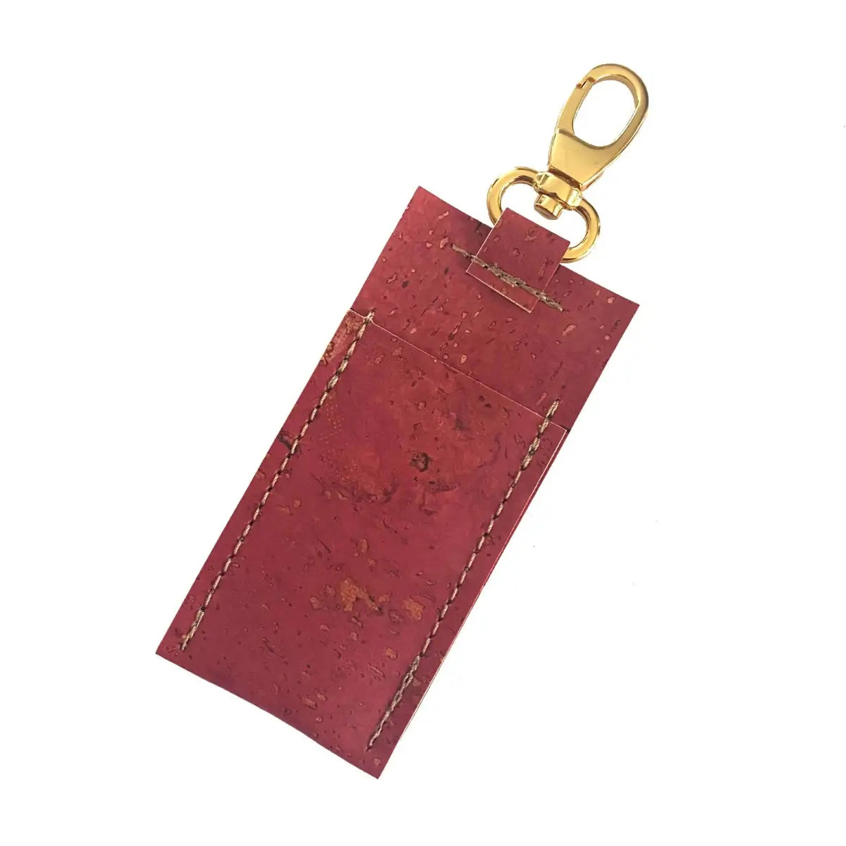 A lip balm holder in red with gold color key clip.