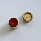 Close up of long wearing rouge red organic tinted lip balm in plastic-free paper tube by River Organics