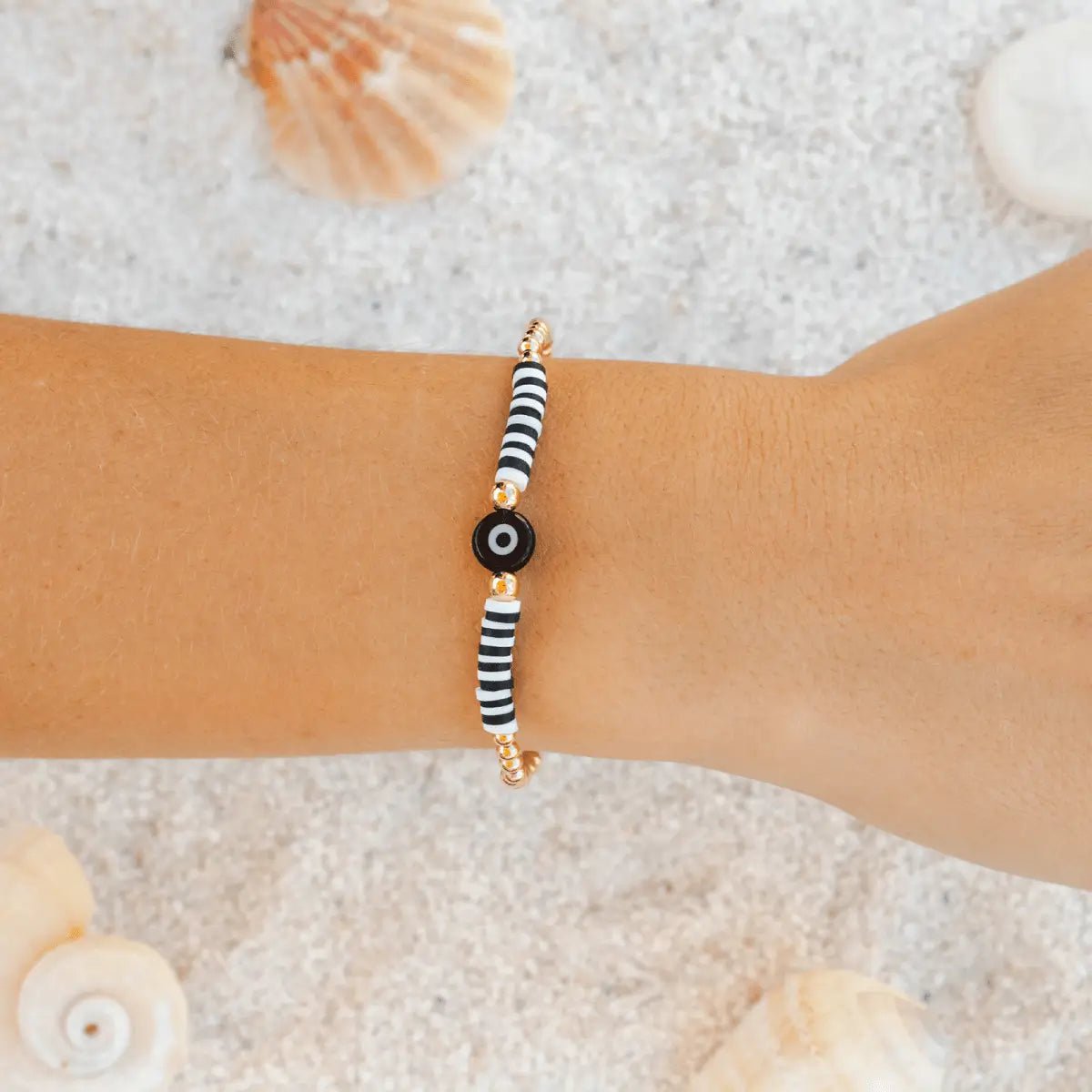 Evil Eye Bracelet with yellow gold round beads and black and white evil-eye shown on a woman's wrist