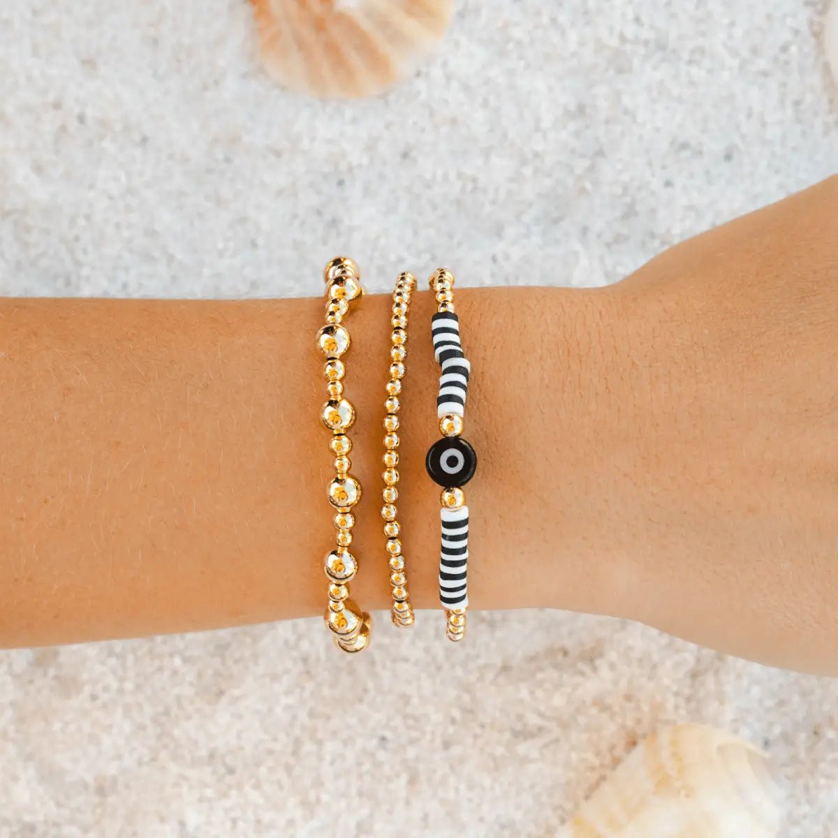 Evil Eye Bracelet by Lotus and Luna worn with other bohemian style bracelets at Elle and Willow