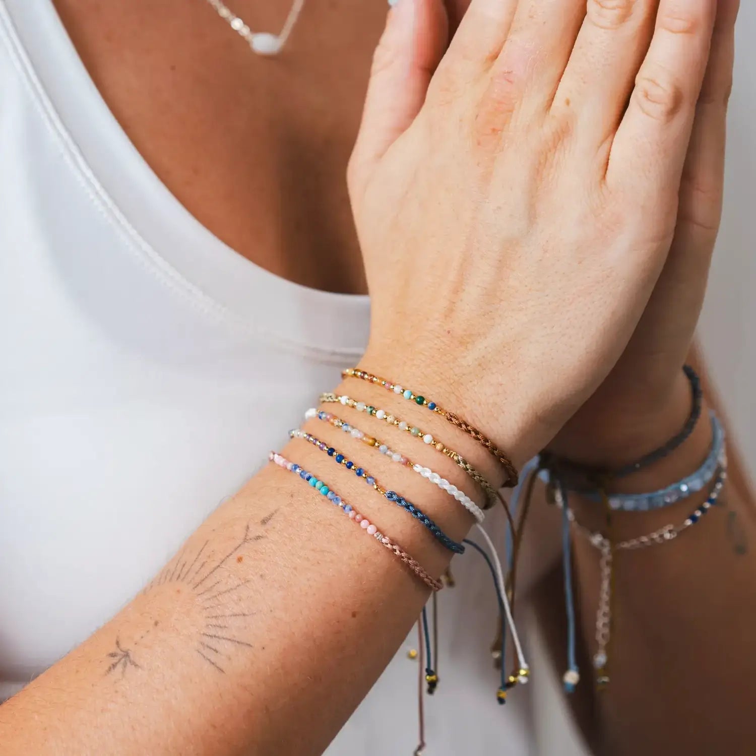 lotus and luna namaste bracelets with small gemstones on an adjustable length cotton slider cord