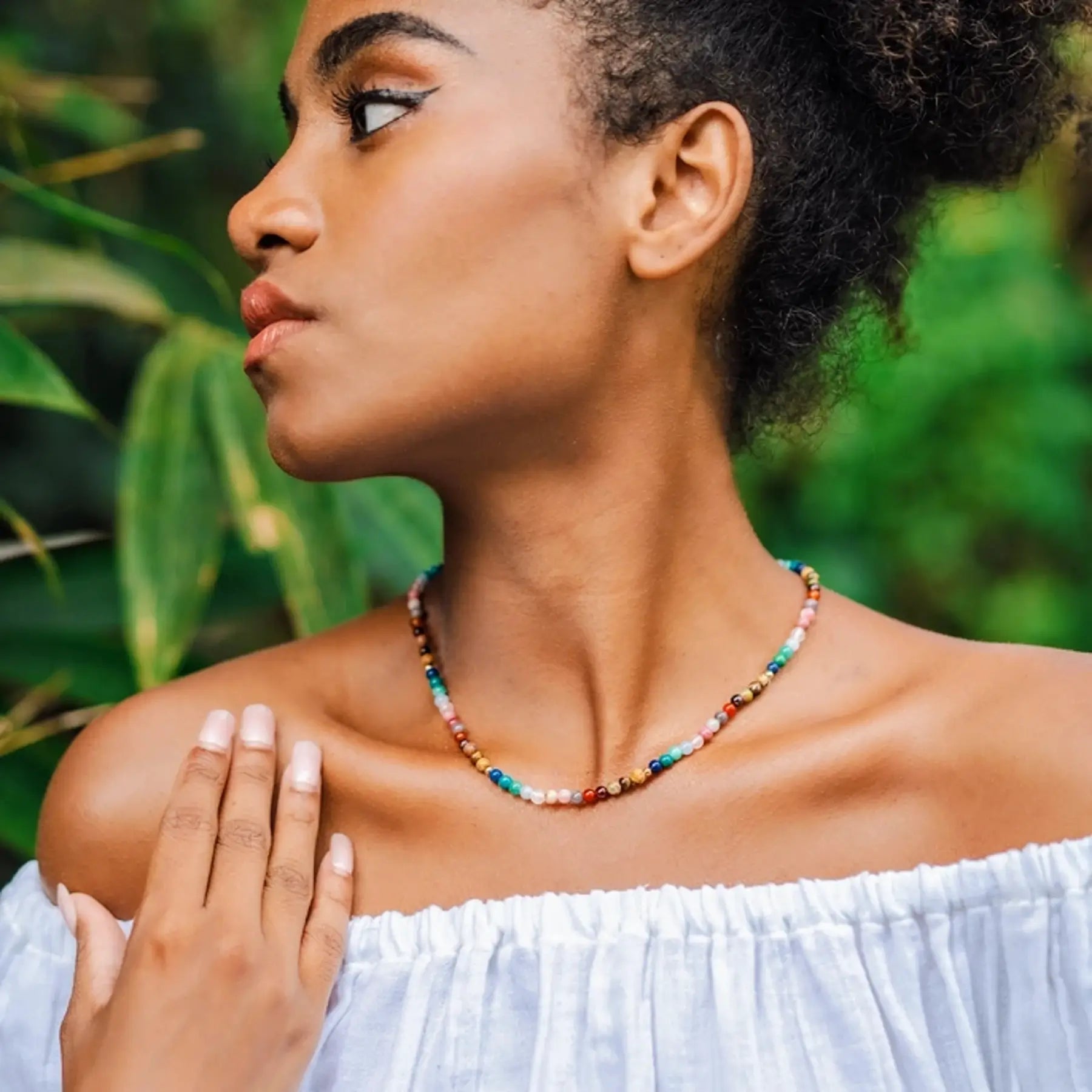 woman wearing a chakra necklace with multi colored stone beads