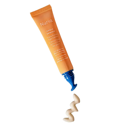 Nuria Beauty Eye Cream triple action eye cream mini size tube with cream swirled on a background showing it's smooth formula.
