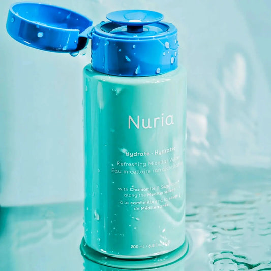 Micellar water in a blue and green bottle with 'Nuria' branding on a light blue background