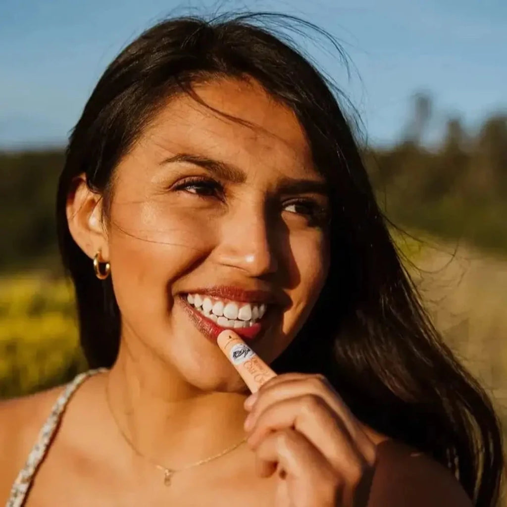 Woman Putting on Pink Grapefruit Organic Tinted Lip Balm - Blue Heron Botanicals