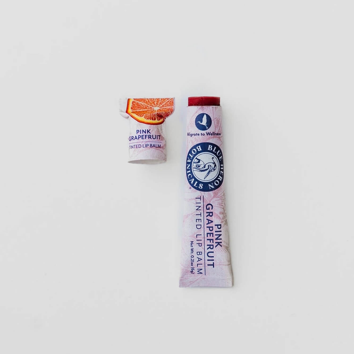 Ruby Red Tinted Lip Balm + Lip Stain with Organic Grapefruit Oil in eco-friendly packaging, featuring a grapefruit slice and Blue Heron Botanicals branding.