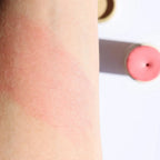 Organic peach blush stick applied to skin