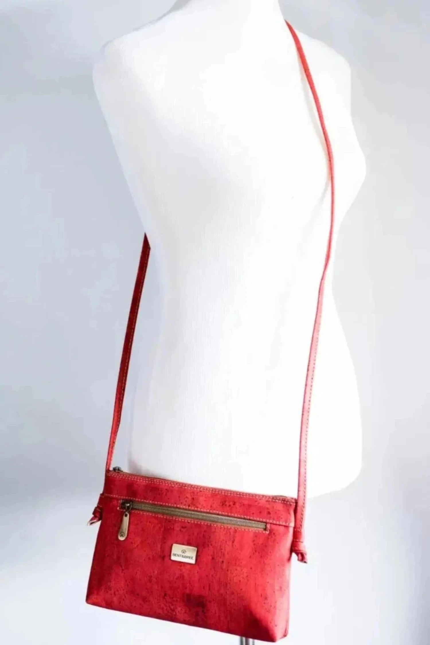 Red cork crossbody bag on shoulder of mannequin