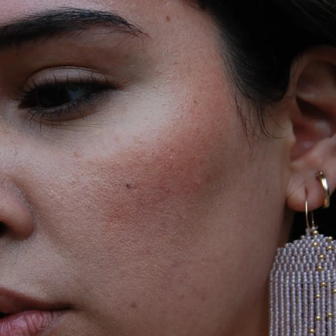 Close-up of a woman's face with a focus on her cheek wearing river organics pinch pink blush