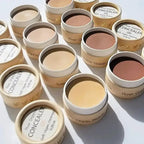 River Organics cream concealer color range from fair skin to tan skin shown in plastic-free, zero waste paper pots