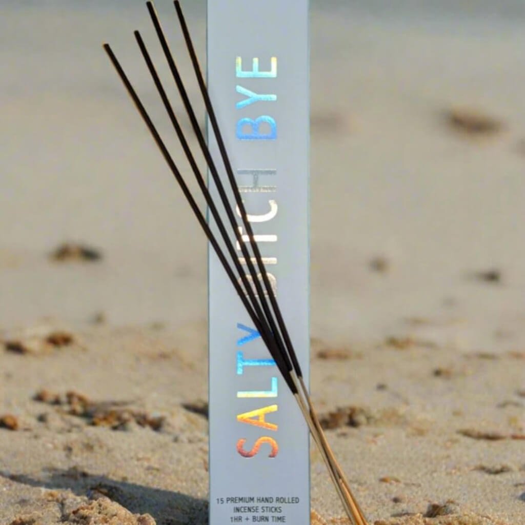 Salty Witch Bye incense sticks on a sandy background