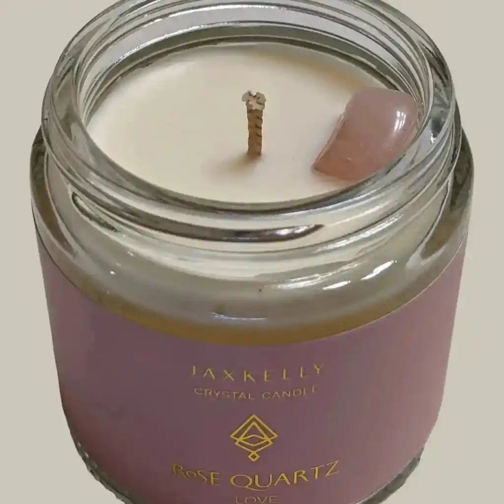 a candle with a small piece of pink quartz in it