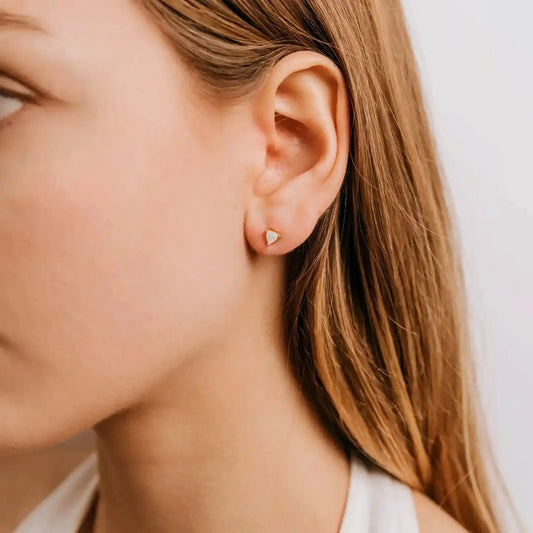 White Mother of Pearl Earrings by JaxKelly shown worn on ear, featuring minimalist gold stud design. Elegant gemstone earrings for everyday wear.