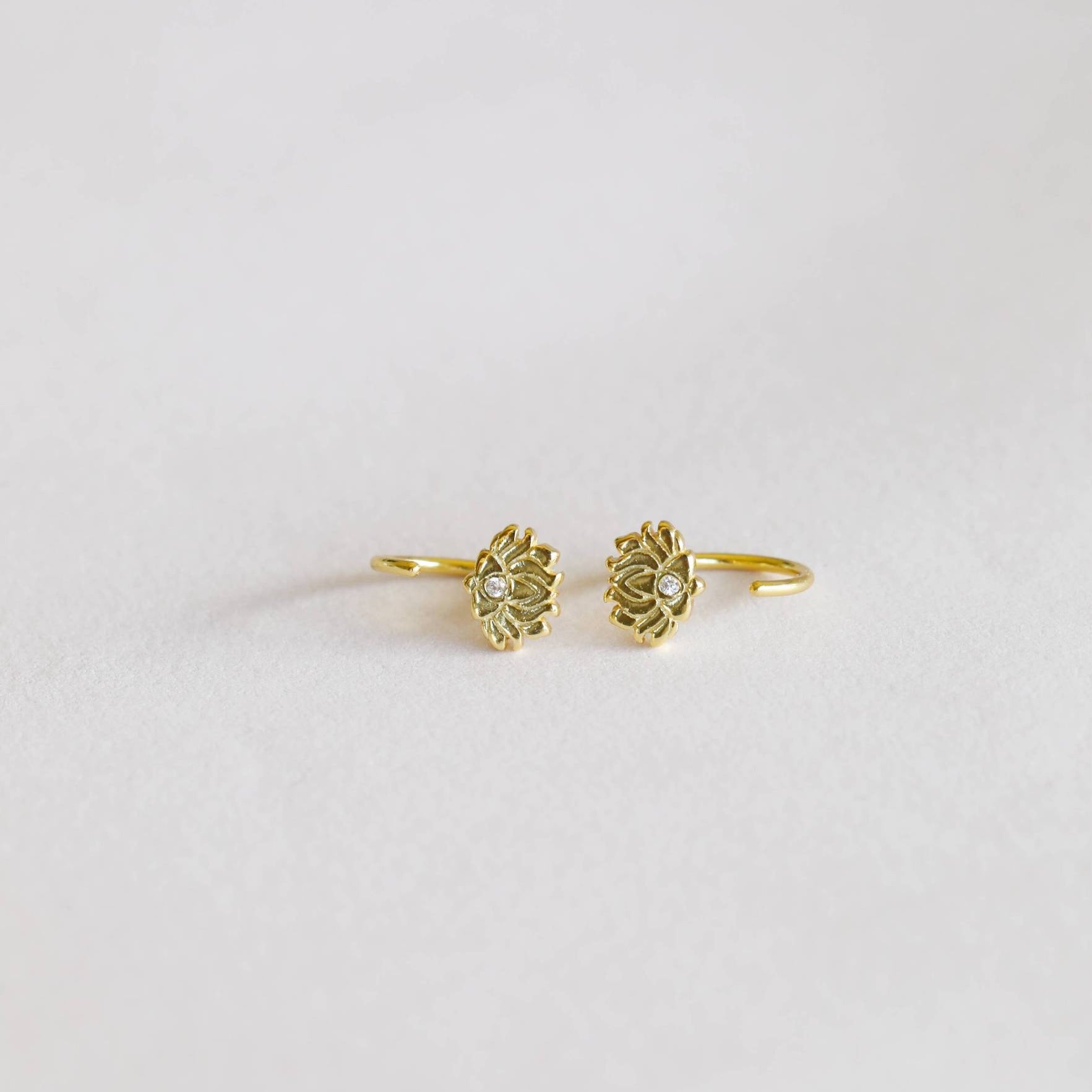 a pair of gold earrings on a white background